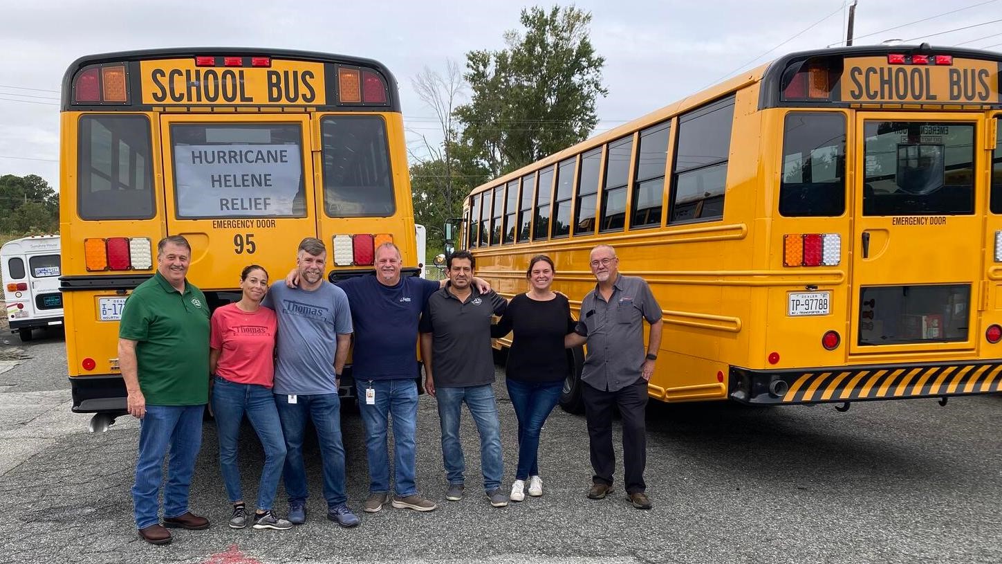 Helper standing in front of buses