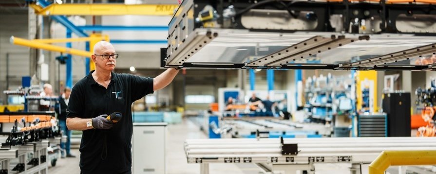 Employee with a truck battery in production
