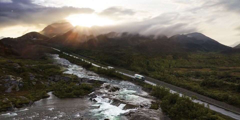 Battery-electric Truck drives above a bridge in a beautiful natural surroundingaft